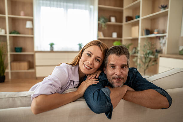 istock Happy couple relaxing together on sofa at home 2225548899