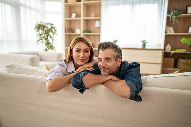 istock Happy mature couple relaxing on sofa at home 2225548929
