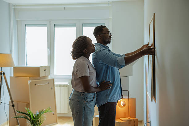 istock Couple decorating new home by hanging artwork on wall 2225550328