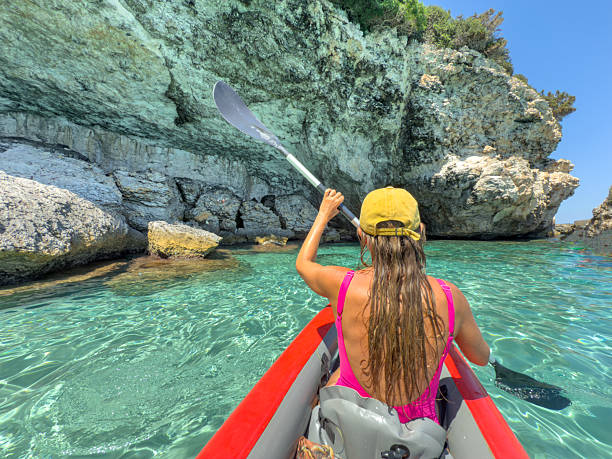 istock Woman Kayaking Near Rocky Coastal Cliffs 2225555269