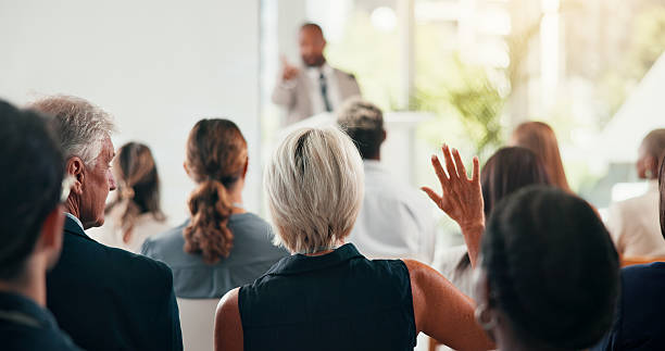 istock Presentation, question and speaker with business people in office for conference, training and meeting. Corporate, answer and workers with hands raised in discussion, convention and finance seminar 2225556836