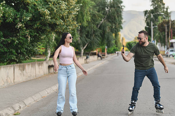 Supportive Male Friend Taking Video of Female While She is Rollerblading For First Time