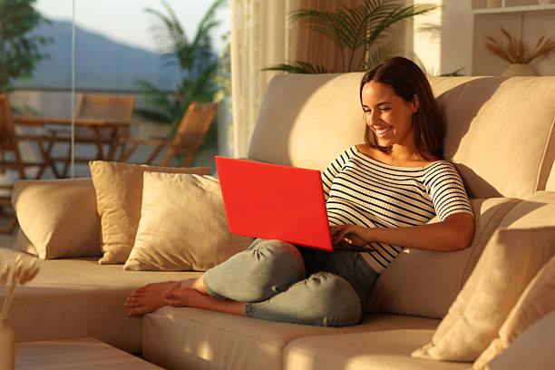 istock Happy woman at sunset using red laptop at home 2225558698
