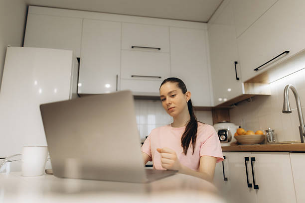 istock Woman Working on Laptop in Bright Modern Kitchen Interior 2225562579