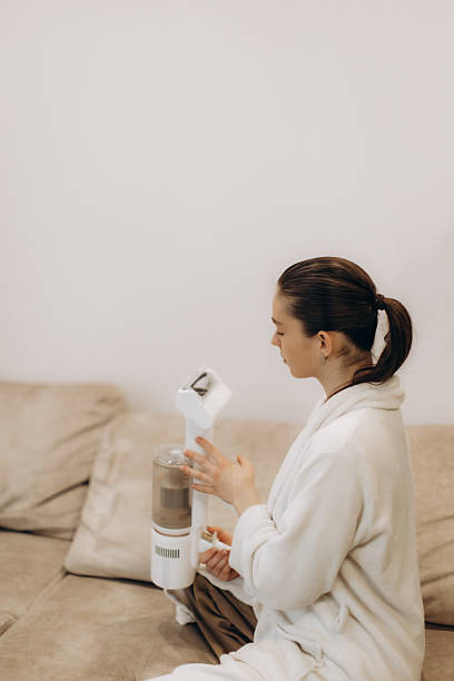 istock Woman Using a Handheld Vacuum Cleaner on a Comfortable Couch at Home 2225562588