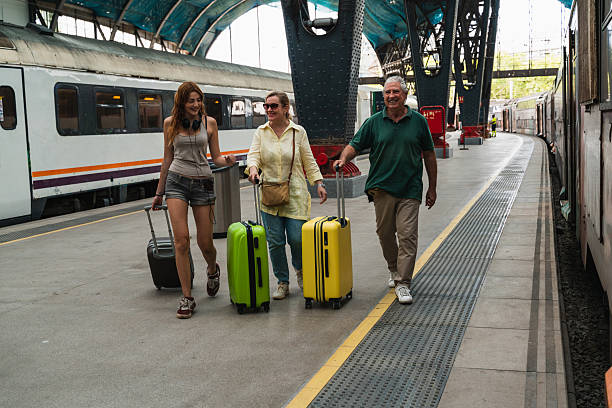 istock Family travel by train family walking on train platform pulling luggage. Intergenerational connection and journey 2225564620