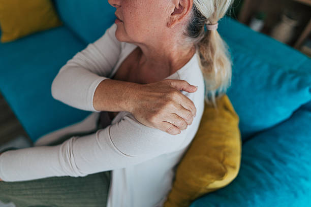 istock Senior woman experiencing shoulder pain while sitting on sofa 2225565687