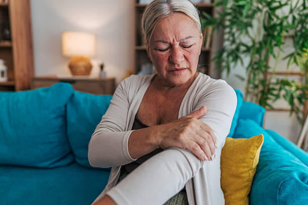 istock Senior woman suffering from arm pain while sitting on sofa 2225565786