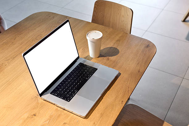 istock Laptop with blank screen and coffee cup on wooden table 2225565988