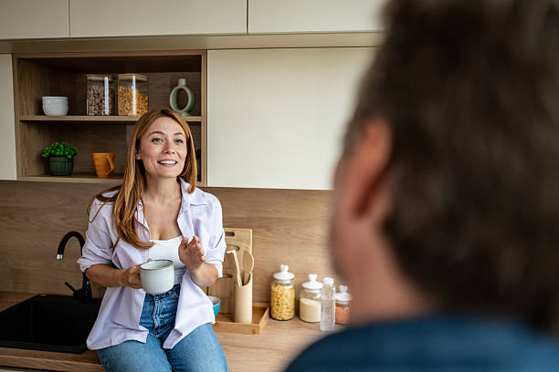 istock Cheerful woman chatting with husband in kitchen while having coffee 2225568008