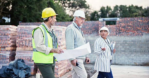 istock Business people, engineer or walking with blueprint at site for construction planning or development. Group, employees or contractors with floor layout or documents for industrial building or project 2225568665
