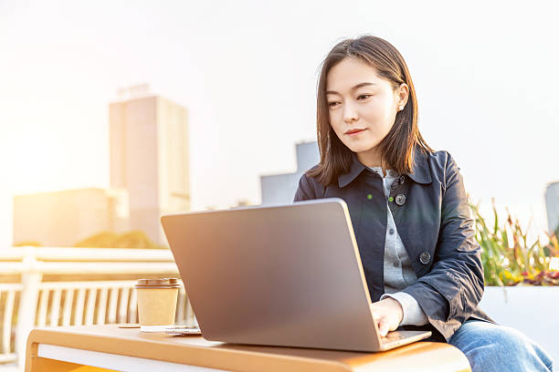 istock Professional woman working on a laptop in an outdoor setting 2225569736
