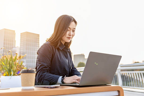 istock Professional woman working on a laptop in an outdoor setting 2225569744