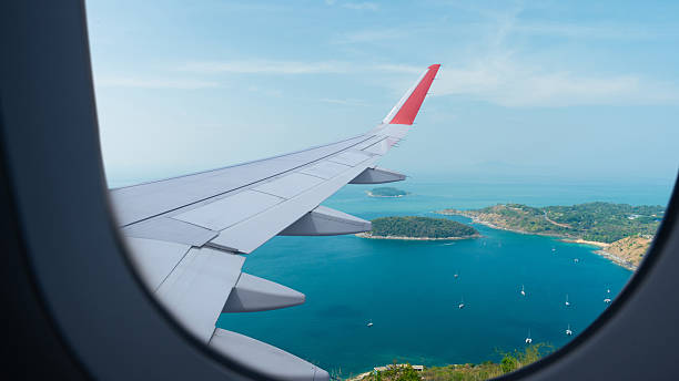 istock Airplane flying low over sea, view from plane window of plane wing and sky 2225572173