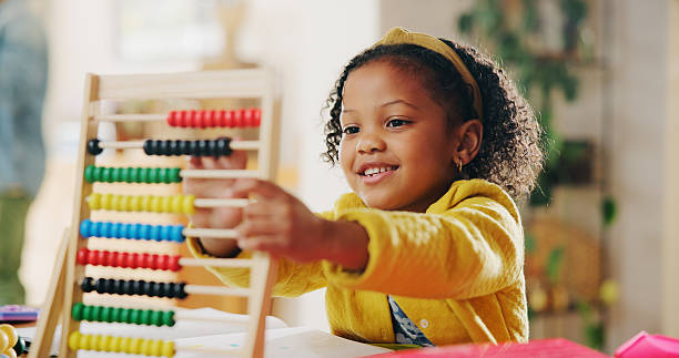 istock Education, learning and child with abacus, happy and counting with beads for homework and practice. House, student and girl with equipment for knowledge, growth and development for maths in apartment 2225572422