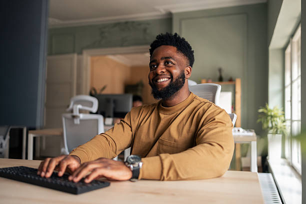 istock Smiling Professional in Modern Office Working on Computer at Desk 2225572847