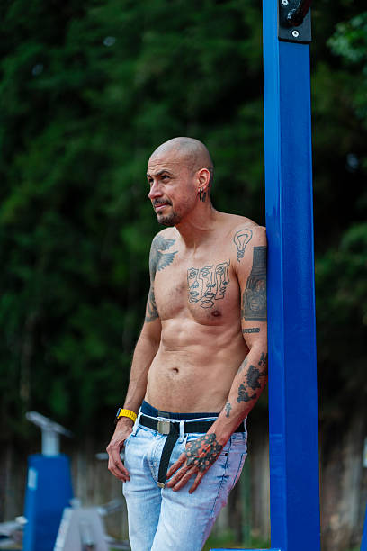 Latino man between 40 and 44 years old rests after finishing his calisthenics routine in the park