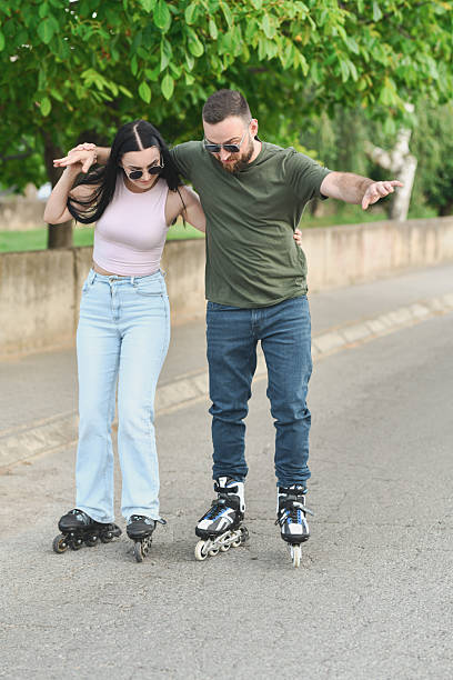 istock Girlfriend Holding Onto Boyfriend As He's Trying Rollerblading for the First Time 2225579568