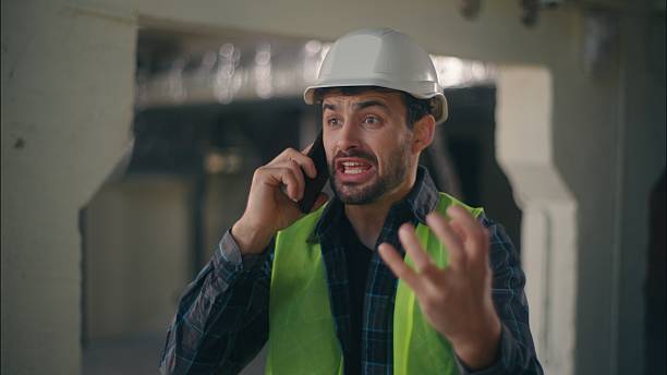 istock Furious Caucasian guy foreman speaking mobile phone in construction builder engineer male shouting angry inspector man arguing cellphone call conversation mad technician complain working build problem 2225579970