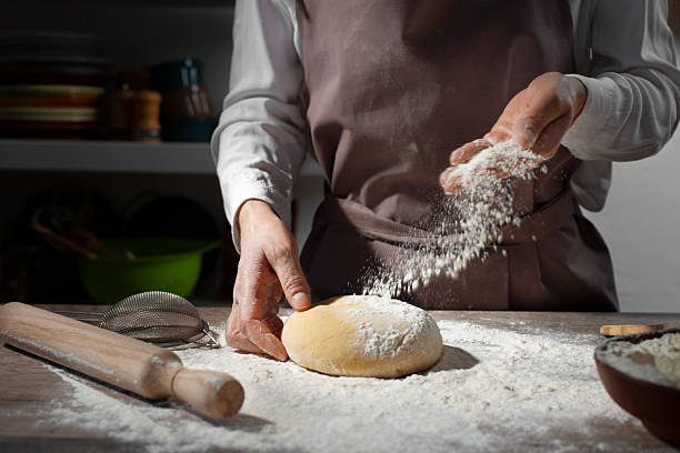 istock Baking concept. Caucasian female hands throwing flour at the dough. 2225582699