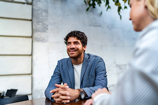 istock Young man talking to coworkers at sidewalk cafe 2225583840