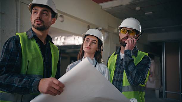 istock Caucasian team colleagues builders discuss blueprint building in construction guys foremen supervisors controlling industrial project draft site paper woman architects manufacturing handymen talking 2225585124