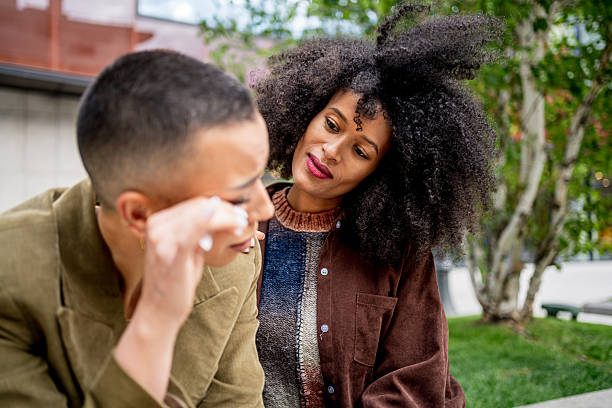 istock Young woman consoling her crying friend outdoors 2225586607