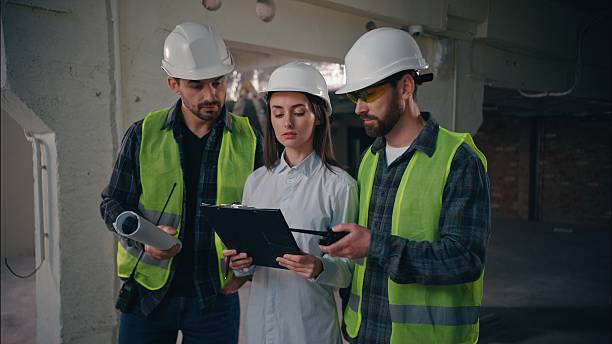 istock Professional Caucasian colleagues team discussing building in construction guys technicians contractors speaking builders communicate walkie talkie woman controller control production inspector plan 2225586645