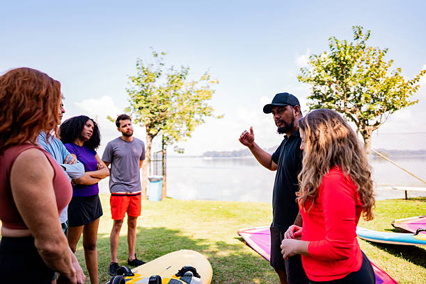 istock Instructor explaining how to windsurf to group outdoors 2225586750