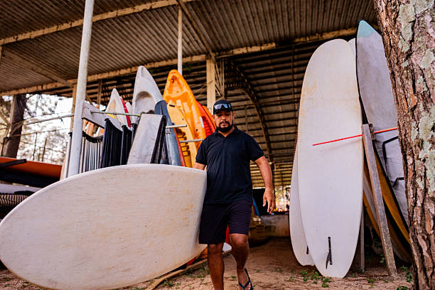 istock Mid adult man carrying a paddleboard 2225588354