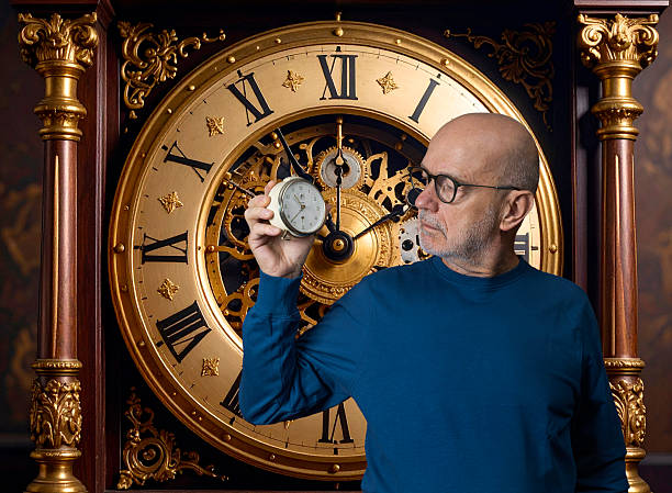 a man looks at an old alarm clock in his hand with a transparent background