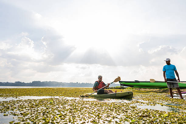 Mature man kayaking with an instructor in a lake