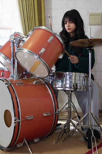 istock woman drummer playing at home 2225589961