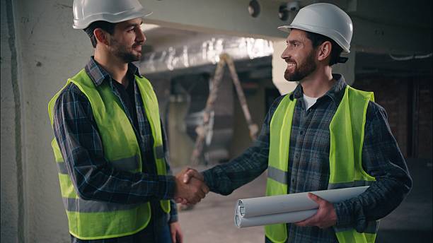 istock Satisfied Caucasian guys discussing draft handshake in construction contractors men technicians repairmen looking blueprint site colleagues builders architects teamwork building architecture project 2225591279
