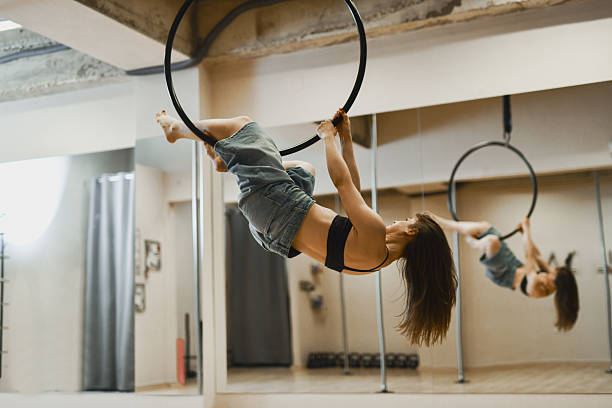 istock Athletic Female Dancer Hanging From Circle in Empty Minimalistic Dance Studio 2225592755