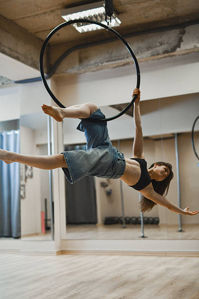 istock Athletic Female Dancer Hanging Upside Down From Aerial Hoop in Minimalist Dance Studio 2225592784