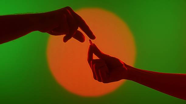 Two Hands Passing a Capsule Against Vibrant Background