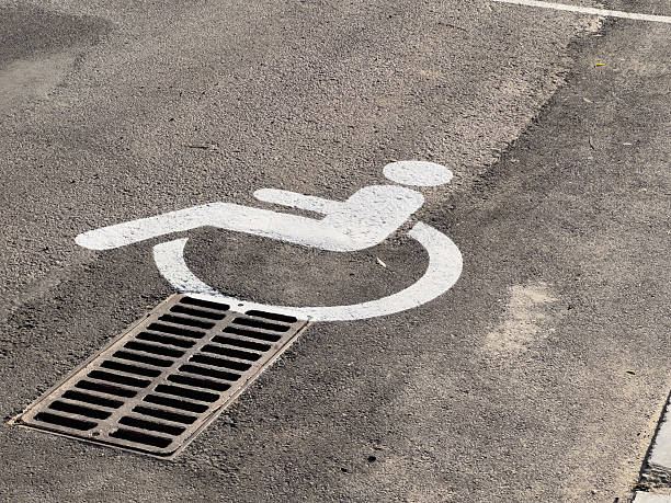 istock A parking space marked with a disability symbol is positioned directly above a drain in a public lot during bright daylight 2225600982