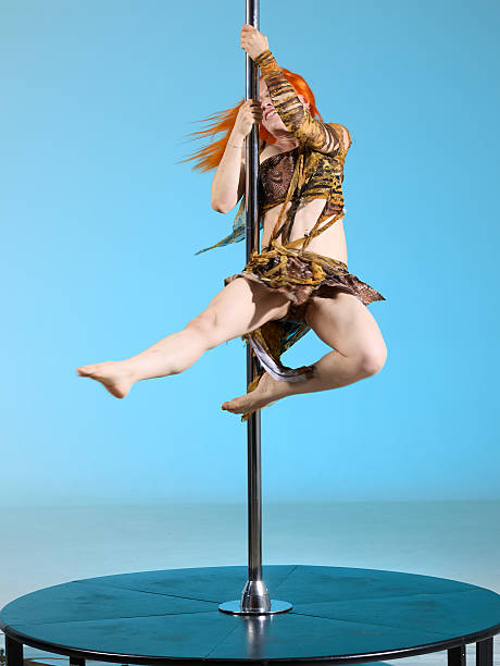 istock Slender red-haired young woman spinning in pole dance 2225601048
