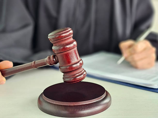 istock Judge presiding over court session while preparing official documentation with gavel in hand during legal proceedings concept 2225602864