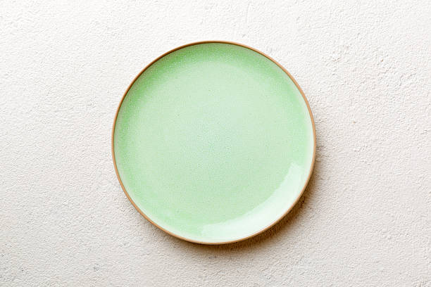 istock Top view of empty green plate on cement background. Empty space for your design 2225603047