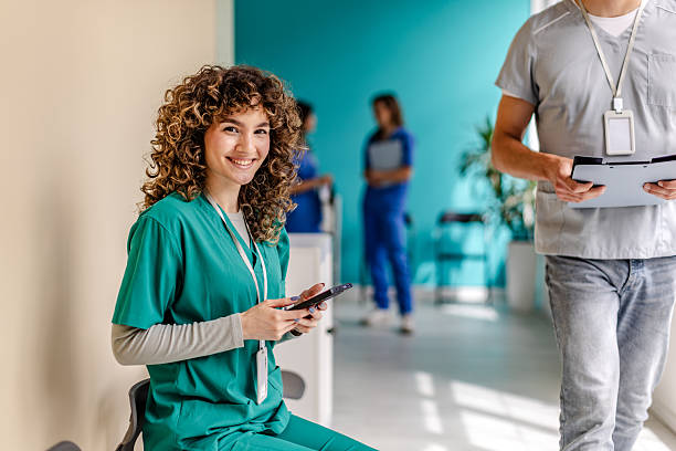 istock Healthcare professionals interacting in a modern hospital setting while a nurse uses a smartphone for communication 2225605241