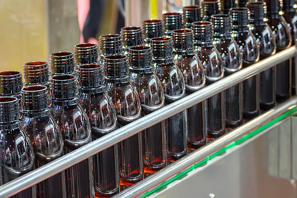 istock The dark brown bottles on the conveyor belt between filling process. 2225606937