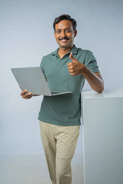 istock Man with laptop showing thumbs up against white background 2225608707