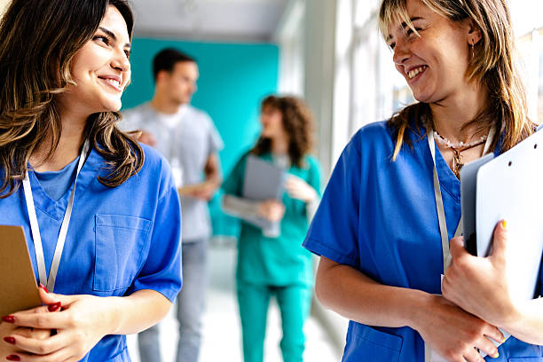 istock Nurses and doctors engage in friendly conversation in a hospital corridor while attending to patient care activities 2225608750