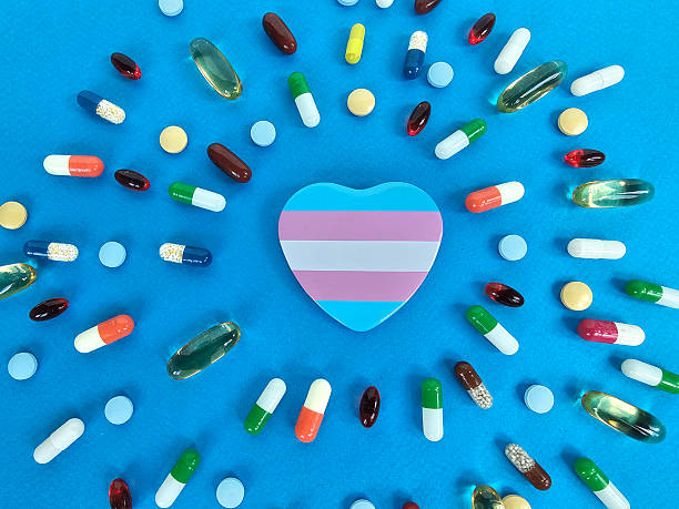A heart-shaped object with horizontal stripes is surrounded by various colorful pills on a vibrant blue surface, representing themes of health and medication diversity concept