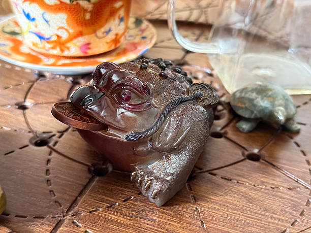 istock Fortune frog with coin on tea table during traditional tea ritual. Prosperity, symbolism and harmony within the tea ceremony atmosphere 2225610048