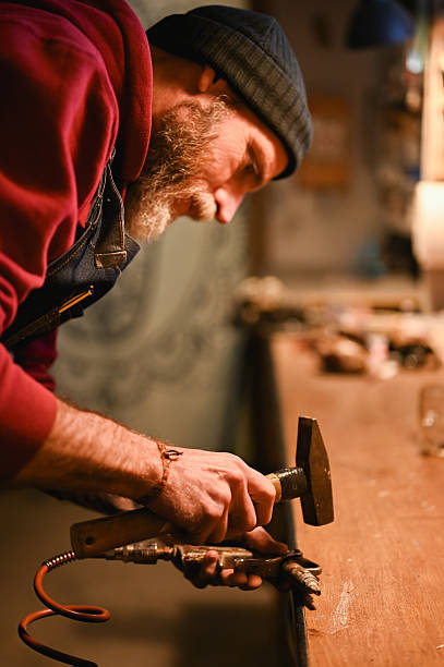 istock Craftsman concentrating on shaping metal in workshop 2225610526