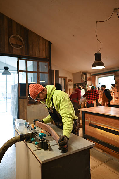 Carpenter working wood with a router in workshop