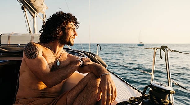 istock Young man enjoying a peaceful sunset on sailboat during summer vacation 2225613681